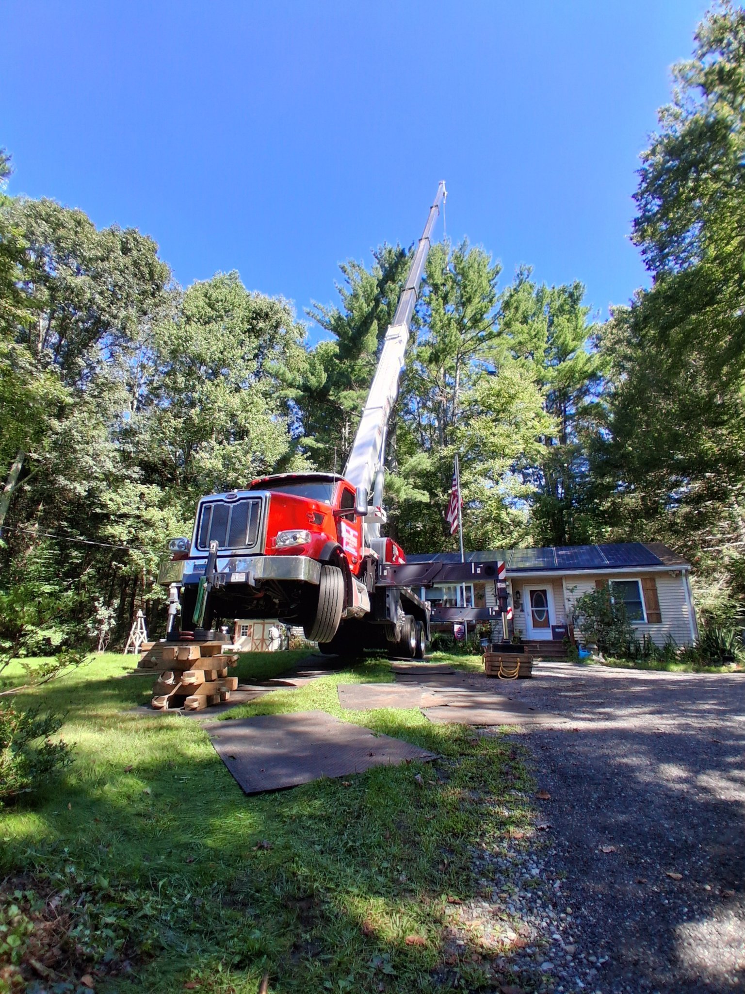 Elliott Tree Service crane truck set up for a tree removal in Connecticut Elliott Tree Service crane set up on mats for a crane-assisted removal